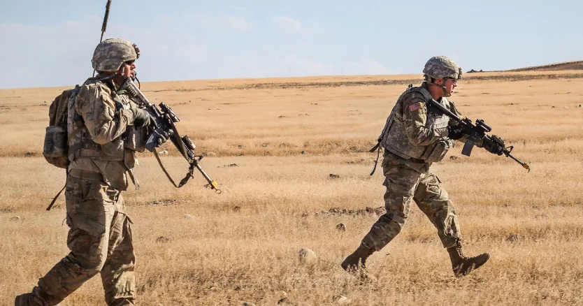 Two soldiers crossing an open field