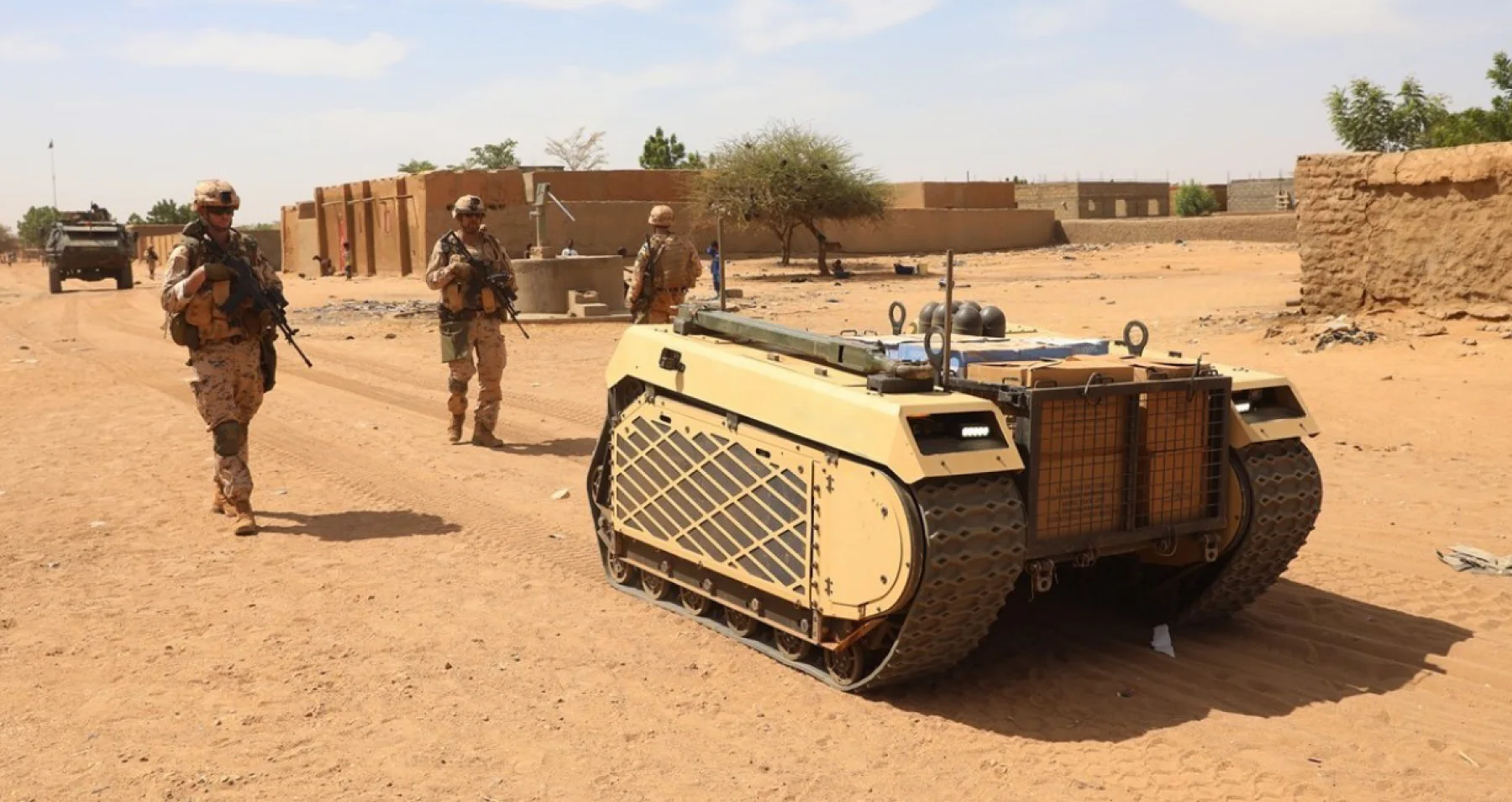 Soldiers and an unmanned ground vehicle operating together