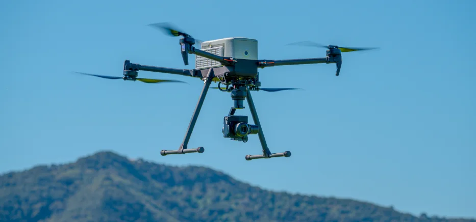 Camera-equipped drone flying above mountains